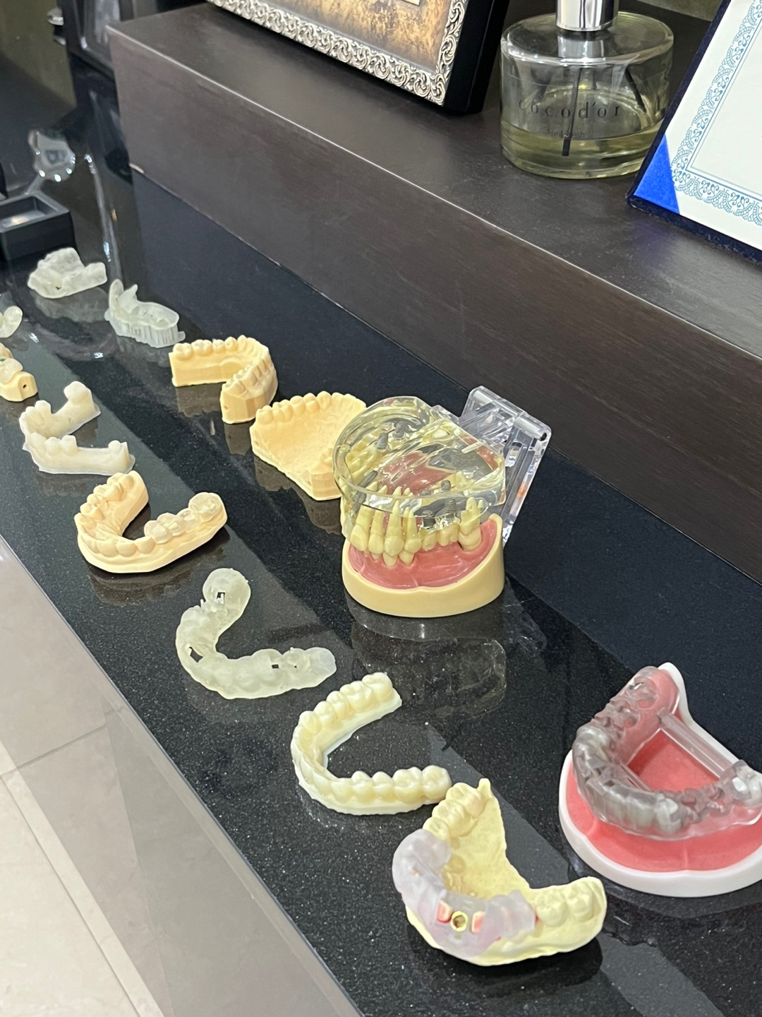 어두운 상판 위에 치아 모형과 보철물 여러 개가 나란히 놓인 모습